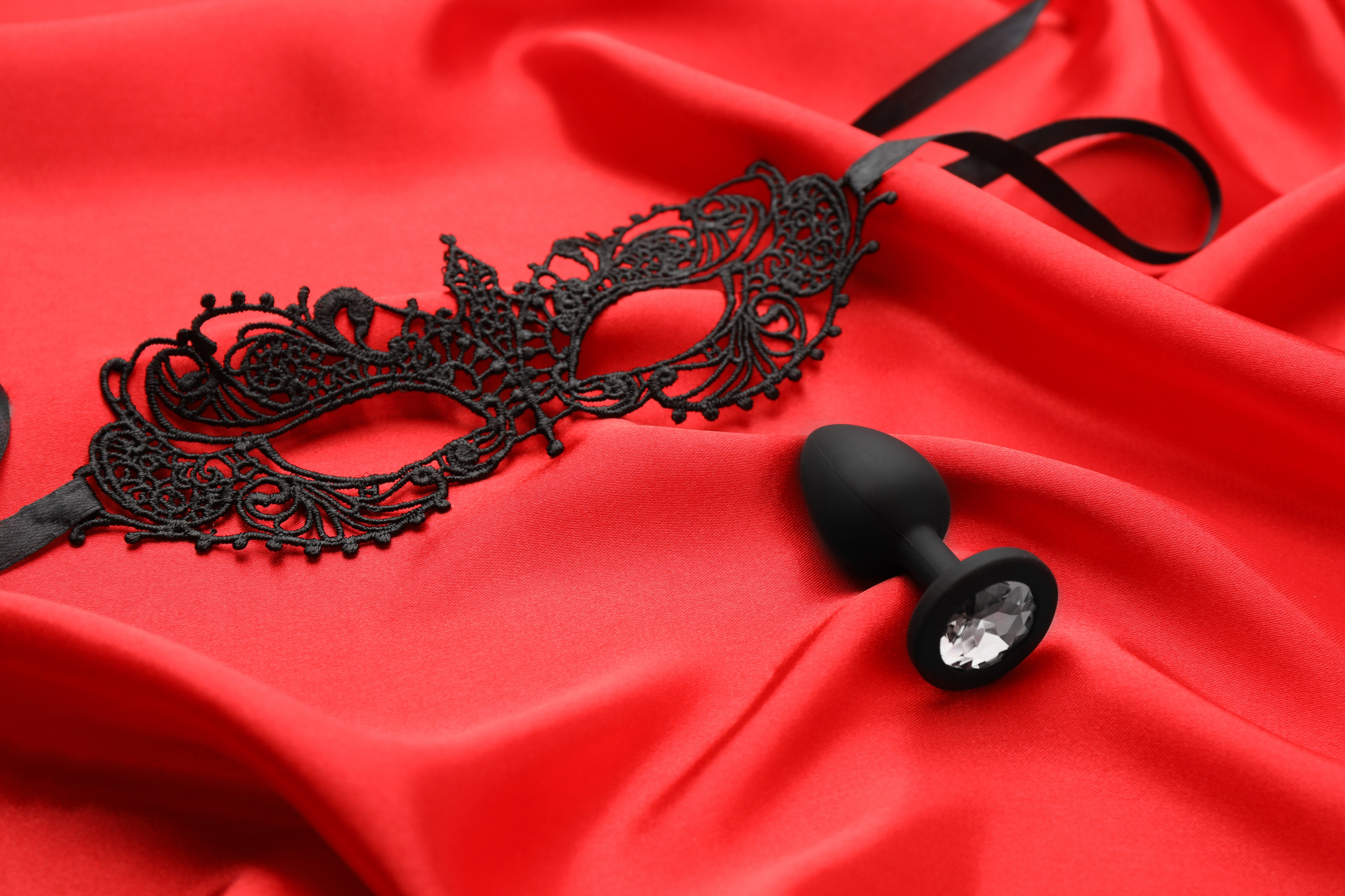 Black Lace Mask and  Plug on Red Fabric